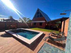 a backyard with a swimming pool and a church at Cabaña Premium Ñakurutu de La Mala Junta in Atyrá