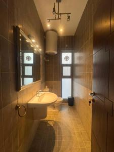 a bathroom with a sink and a toilet and a mirror at Nine homes in Amman