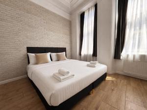 a bedroom with a large bed with towels on it at Lev Or Aparthotel in Bucharest