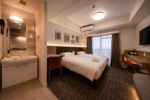a hotel room with a bed and a sink at Hotel Arashi Nippombashi 2 No008 in Osaka