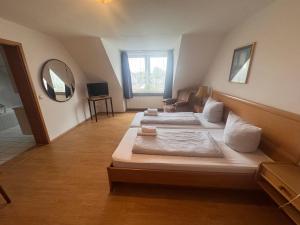due letti in una stanza con uno specchio di Hotel Rademacher a Wittmund