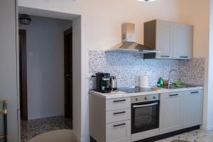 a small kitchen with white cabinets and a sink at SanPatrizio Guest House in Torre San Patrizio +14 photos