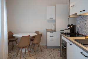 a kitchen with a table and chairs in it at SanPatrizio Guest House in Torre San Patrizio