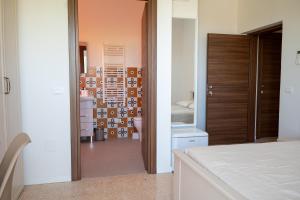 a bedroom with a door leading to a room with a bed at SanPatrizio Guest House in Torre San Patrizio