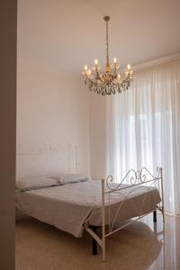 a bedroom with a bed with a chandelier at SanPatrizio Guest House in Torre San Patrizio