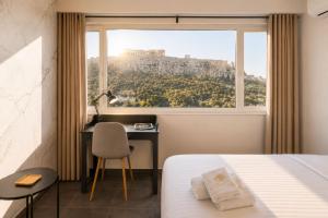 a bedroom with a bed and a desk and a window at Elite Ermou Suites in Athens