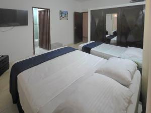 a room with two beds and a television in it at Hotel Montserrat Luxury in Valledupar