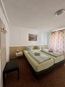 a bedroom with two beds and a table in it at Hotel Gästehaus Altena in Altena