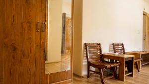 a dining room with a wooden table and two chairs at Green View Hotel in Leh +22 photos