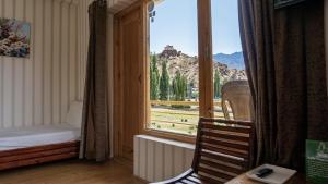 a room with a window with a view of a mountain at Green View Hotel in Leh