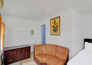 a bedroom with a chair and a bed and a sink at Ari Gusti Residence in Dalung