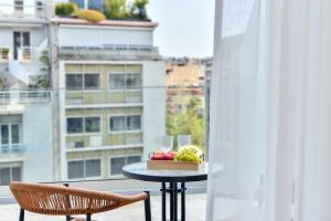 a table with a bowl of fruit on a balcony at Acropolis Lumina in Athens