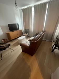 a living room with a couch and a television at Maison Agathe in Brussels
