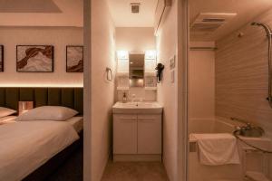a bedroom with a bed and a sink and a tub at Hotel Arashi Nippombashi 2 No008 in Osaka +54 photos