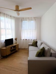 a living room with a couch and a tv at O Recuncho do Castelo in Ribadavia