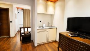 a living room with a television and a kitchen at Vila Centar in Budva