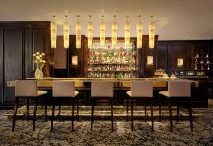 a bar with a table and chairs in a room at The Park Tower Knightsbridge, a Luxury Collection Hotel, London in London