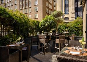 an outdoor restaurant with tables and chairs and buildings at The Park Tower Knightsbridge, a Luxury Collection Hotel, London in London