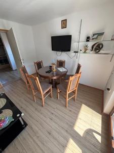 a dining room with a table and chairs and a television at Apartman Brod in Konjska Reka