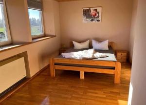 a bed in a room with two windows at Ferien auf dem Pferdehof in Rappin