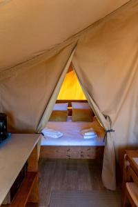 a bed in a tent with two pillows at Domaine Solio - Lodge isolée, nature, animaux in Satillieu