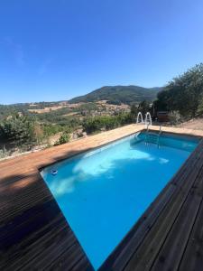 a swimming pool with a view of the hills at Domaine Solio - Lodge isolée, nature, animaux in Satillieu
