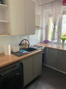a kitchen with a sink and a stove top oven at Blackapartment2Kawalerka in Olsztyn