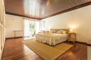 a large bedroom with a bed and a large window at Casa da Palmeira in Sesimbra +80 photos