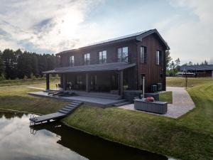 a large house on the side of a river at Galuonu Vilos Vip vila in Inturkė
