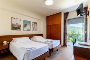 two beds in a room with a balcony at Dynamotel in San Marcello Pistoiese