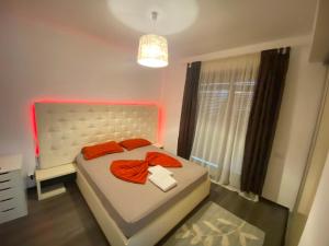 a bedroom with a bed with orange pillows and a window at RC RelaxApart 4 in Dudu