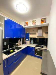 a blue kitchen with white counters and blue cabinets at RC RelaxApart 4 in Dudu