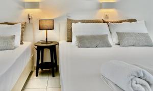 a bedroom with two beds and a lamp on a table at Thalassa Garden Studios in Pefkochori