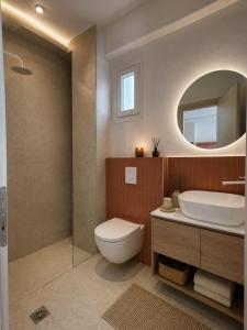 a bathroom with a toilet and a sink and a mirror at Spitaki mou - 1bd house in Mastihari