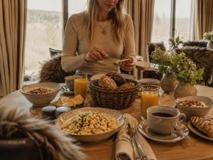 a woman is sitting at a table with food at Naturhotel Die Maise in Hayingen
