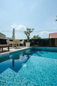 a swimming pool with a table and chairs next to it at Villa The One Mostar with Heated Pool & Jacuzzi in Mostar