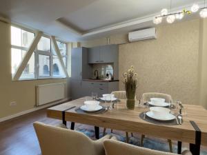 a dining room with a wooden table and chairs at Lev Or Aparthotel in Bucharest