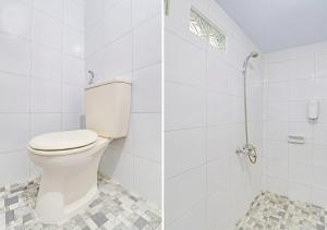 a white bathroom with a toilet and a shower at Ari Gusti Residence in Dalung +3 photos