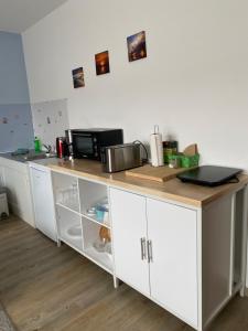a kitchen with a counter with a microwave on it at Pension Dünenhaus in Zempin