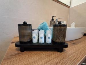 a bathroom counter with four bottles of soap and a sink at Landhaus Eiter in Arzl im Pitztal
