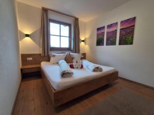 a bedroom with a bed with two stuffed animals on it at Landhaus Eiter in Arzl im Pitztal