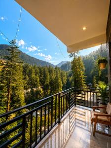 a balcony with a view of the mountains at The Woodpecker Inn Jibhi in Jibhi