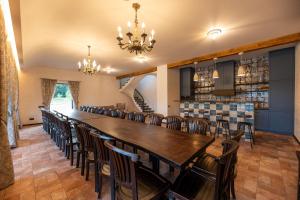a large dining room with a long table and chairs at Galuonu Vilos Vip vila in Inturkė