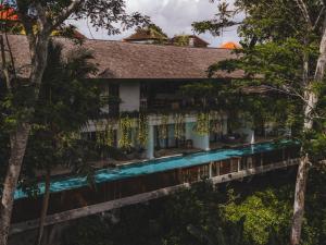 a house with a swimming pool in the trees at The Hidden Paradise Ubud - CHSE Certified in Ubud