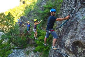 a group of people on a rock wall at Camping Ushuaïa Villages Les Cruses in Ribes