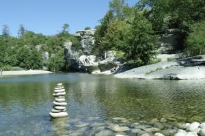 a stack of rocks in the water in a river at Camping Ushuaïa Villages Les Cruses in Ribes +51 photos