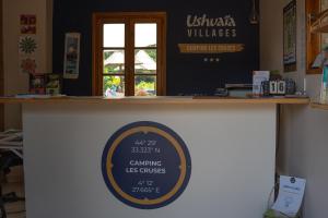 a counter in a restaurant with a sign on it at Camping Ushuaïa Villages Les Cruses in Ribes
