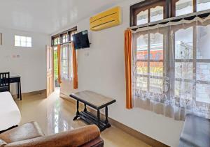 a living room with a table in front of a window at Ari Gusti Residence in Dalung