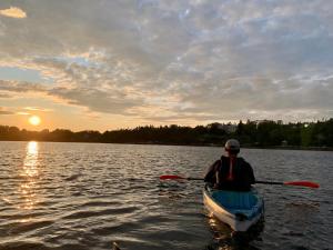 a man in a canoe on a lake at sunset at 181 Oceanside Inn in Peggy's Cove +76 photos
