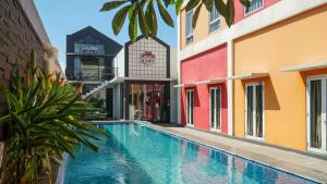 a swimming pool in front of a building at Front One Hotel Purwodadi in Purwodadi